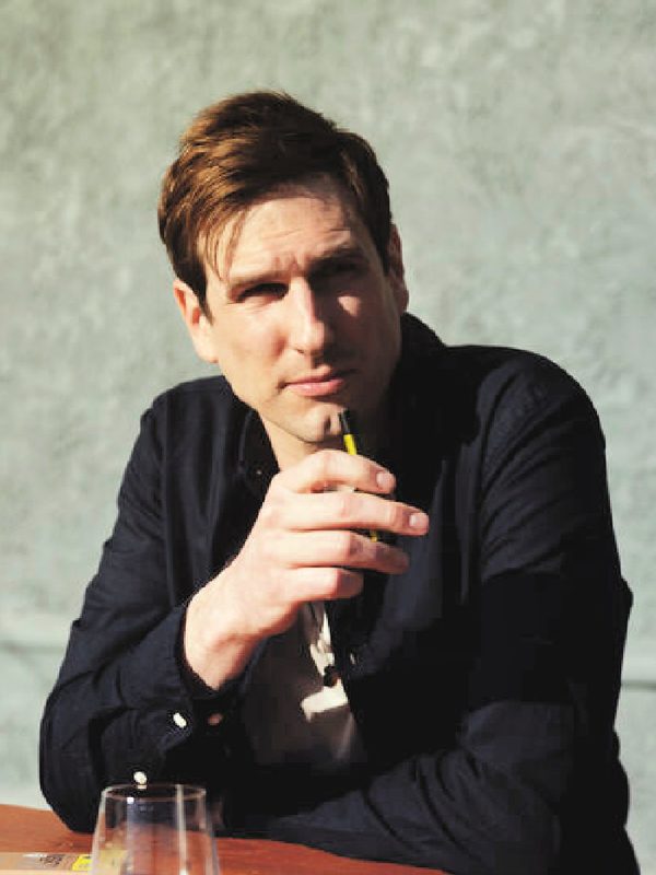 Collin Palmer, seated, holding a pen